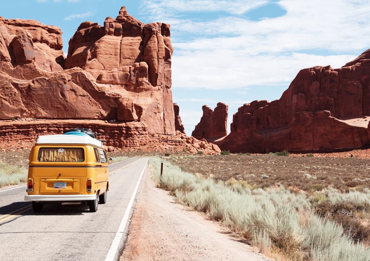 A camper van on a winding road through open countryside.