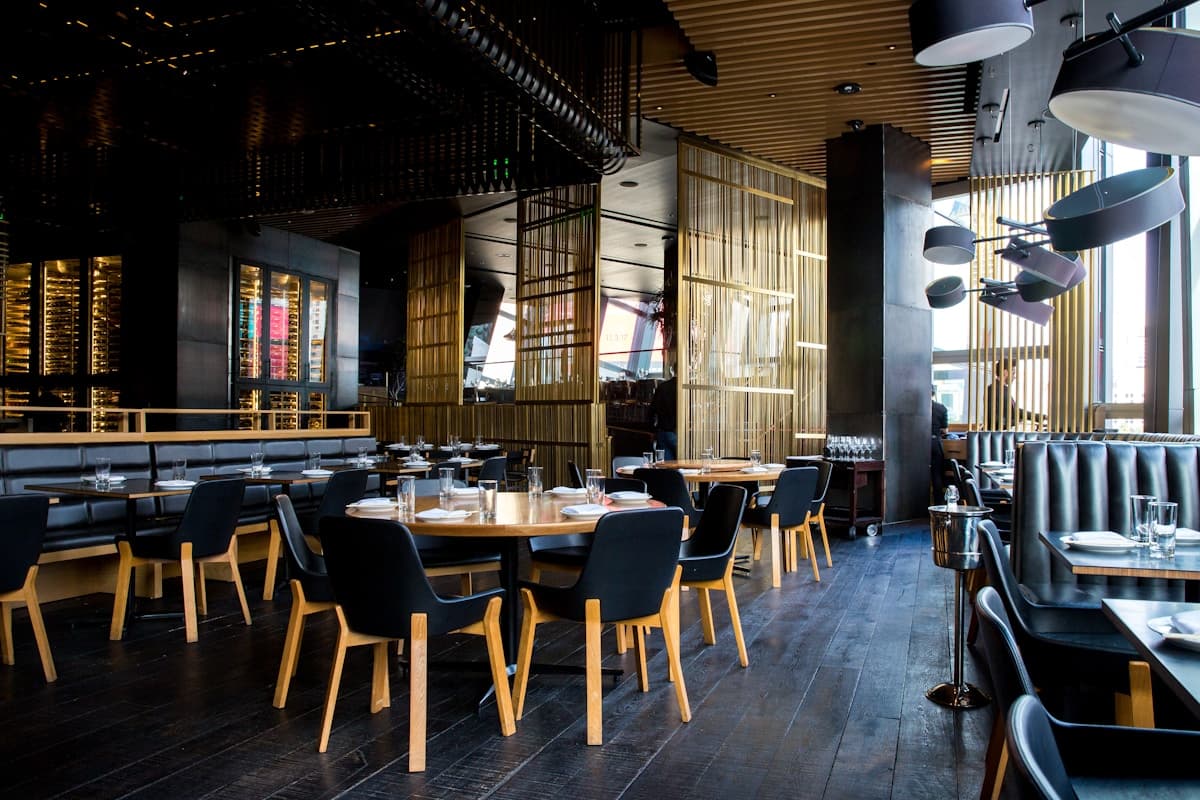 An intimate dining room with warm lighting and a formally set long table.